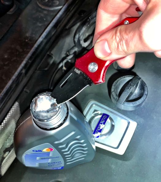 HSR kniv i praktisk brug, skærer folie på oliedunk med motorolie