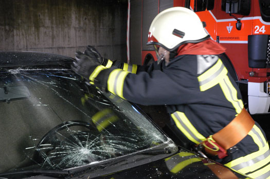 Brandmand der hakker hul i forrude på bil